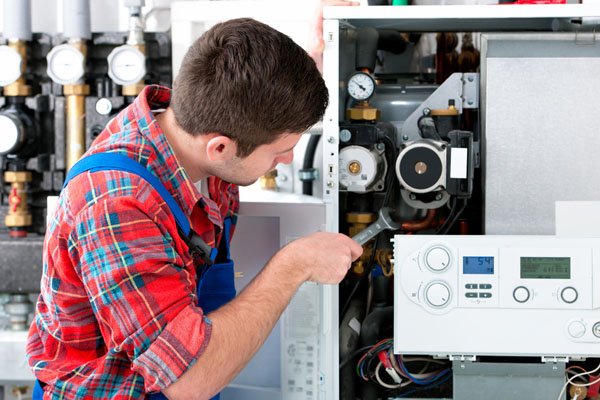 HVAC technician inspecting and repairing boiler controls in Bountiful