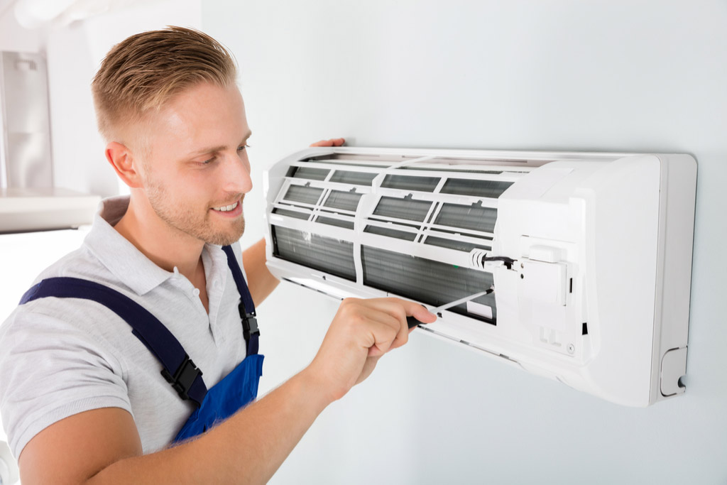 HVAC technician performing ductless air conditioning maintenance in Bountiful