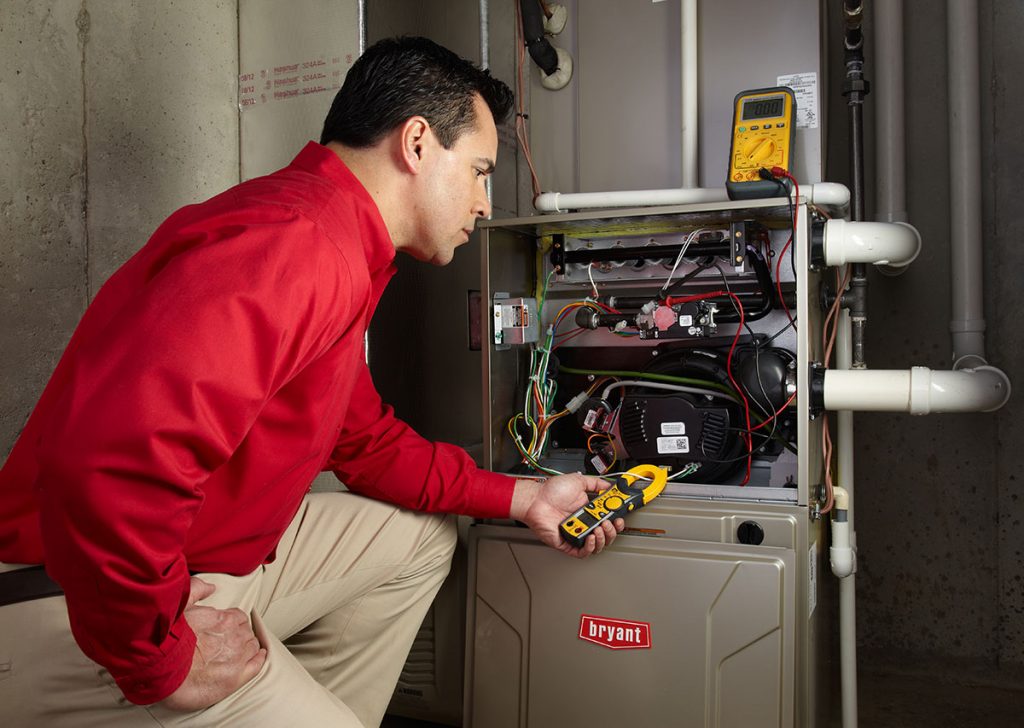 HVAC technician repairing an indoor furnace in Bountiful