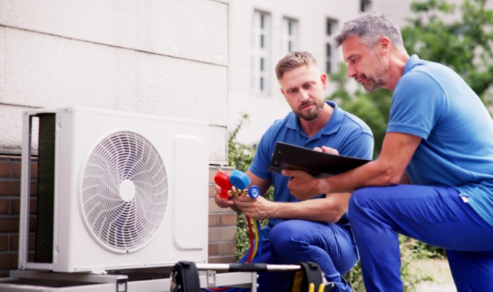HVAC technicians installing an outdoor air conditioning unit in Bountiful