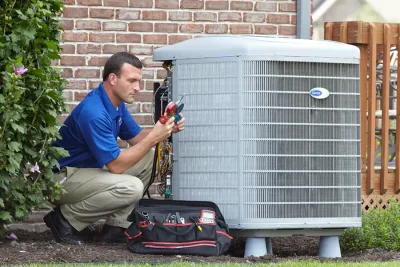 design-air-heating-and-air-conditioning-decatur-il-05 – Copy HVAC technician inspecting an outdoor air conditioning unit in Bountiful, UT