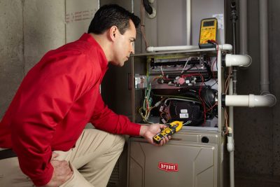furnace repair Heating and air conditioning technician servicing an indoor furnace in Bountiful, UT